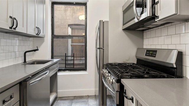 1037 College Ave, Bronx, NY 10456 - kitchen featuring appliances with stainless steel finishes, a sink, decorative backsplash, baseboards, and light countertops