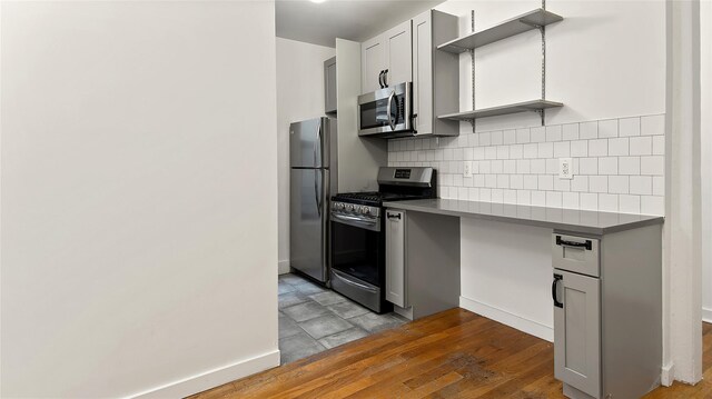 1037 College Ave, Bronx, NY 10456 - kitchen featuring appliances with stainless steel finishes, tasteful backsplash, gray cabinets, dark countertops, and wood finished floors