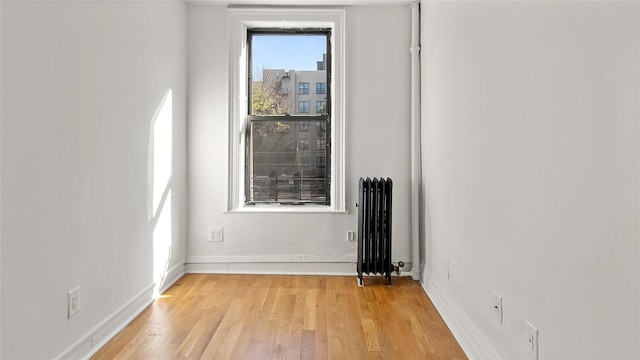1037 College Ave, Bronx, NY 10456 - spare room featuring radiator, light wood-type flooring, and baseboards