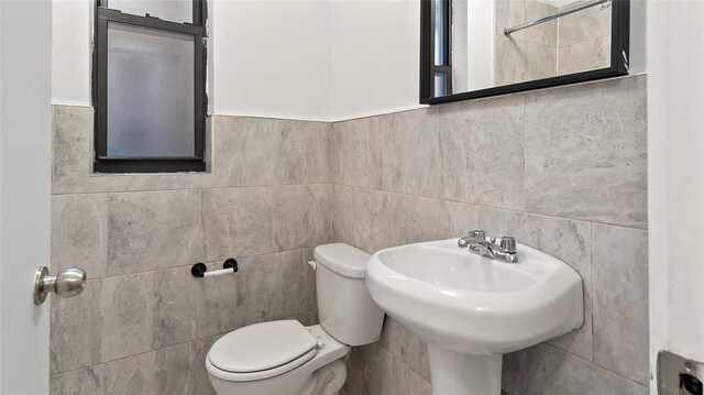 1037 College Ave, Bronx, NY 10456 - bathroom featuring tile walls, toilet, and a sink
