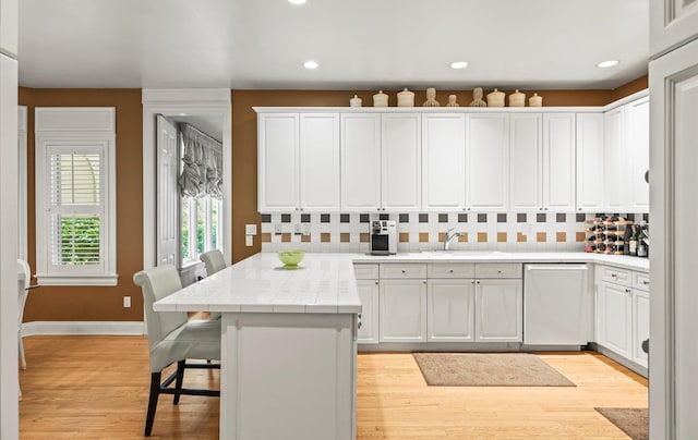 5 Hickory Ct, Manhasset, NY 11030 - kitchen featuring dishwashing machine, a peninsula, a sink, white cabinets, and recessed lighting