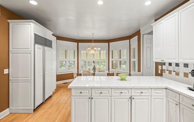 5 Hickory Ct, Manhasset, NY 11030 - kitchen featuring a peninsula, a chandelier, baseboards, recessed lighting, and white cabinetry