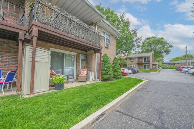 42 Springwood Dr, North Babylon, NY 11703 - exterior space with a lawn, uncovered parking, brick siding, and a cooling unit