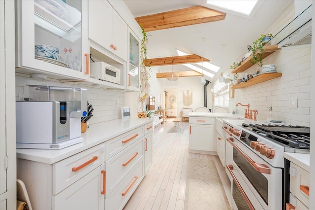 96 Alabama St, Long Beach, NY 11561 - kitchen with white appliances, backsplash, light countertops, white cabinets, and glass insert cabinets