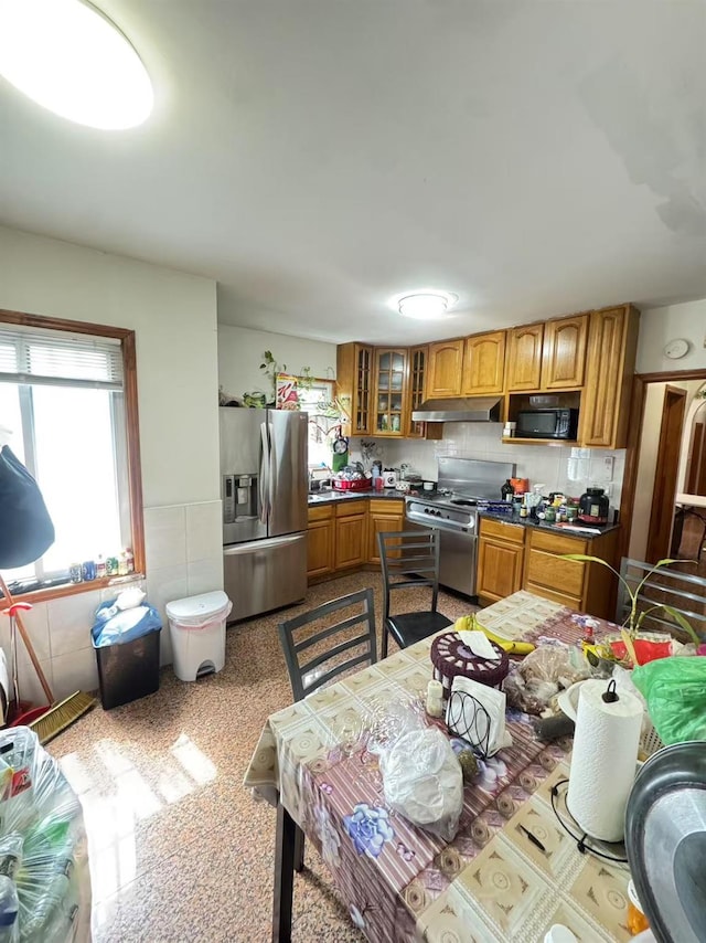 41-09 Forley St, Elmhurst, NY 11373 - kitchen featuring stainless steel refrigerator with ice dispenser, under cabinet range hood, stove, black microwave, and brown cabinets