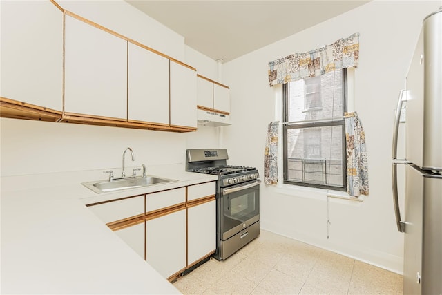 2187 Holland Ave Unit 2J, Bronx, NY 10462 - kitchen featuring gas range, freestanding refrigerator, light countertops, under cabinet range hood, and white cabinetry