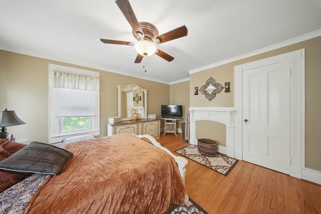 482 Scotchtown Ave, Middletown, NY 10941 - bedroom with light wood-type flooring, crown molding, a ceiling fan, and a fireplace with flush hearth