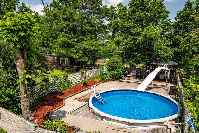 482 Scotchtown Ave, Middletown, NY 10941 - view of pool featuring a water slide, a patio area, a fenced backyard, and view of wooded area