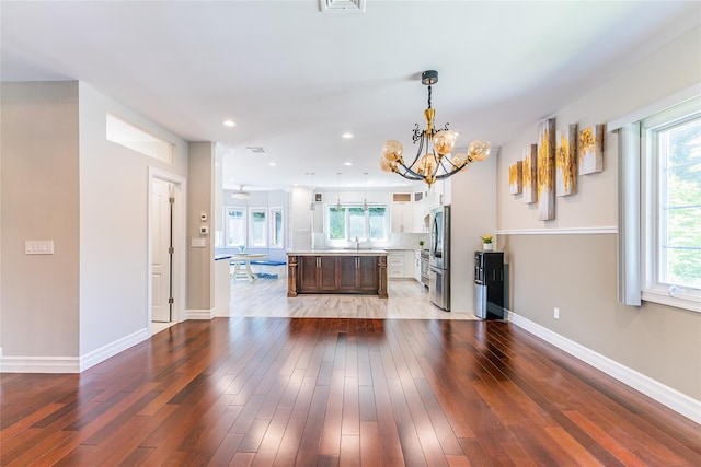 151 Birch Dr, Manhasset Hills, NY 11040 - unfurnished living room with a chandelier, healthy amount of natural light, wood finished floors, and recessed lighting
