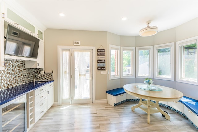 151 Birch Dr, Manhasset Hills, NY 11040 - kitchen featuring dark countertops, wine cooler, plenty of natural light, glass insert cabinets, and recessed lighting