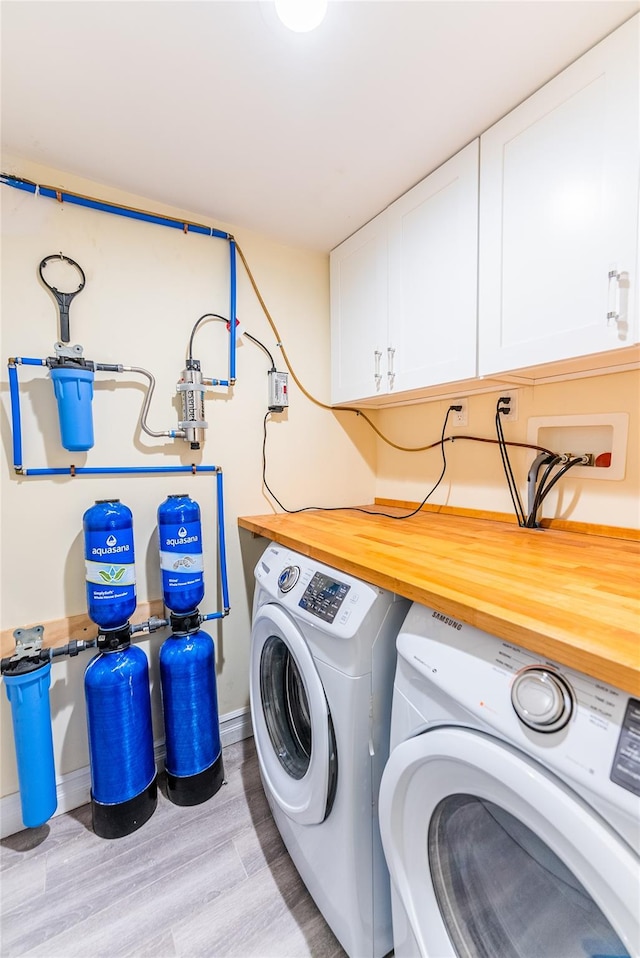 151 Birch Dr, Manhasset Hills, NY 11040 - laundry room featuring separate washer and dryer, cabinet space, and light wood-style flooring