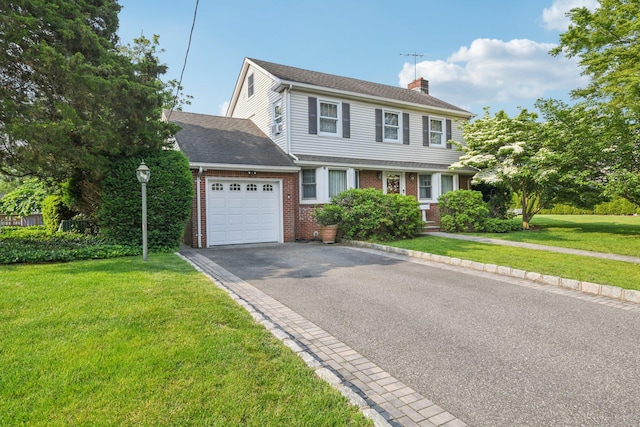 54 Ogden Ave, East Williston, NY 11596 - view of front facade with an attached garage, a chimney, brick siding, asphalt driveway, and a front lawn