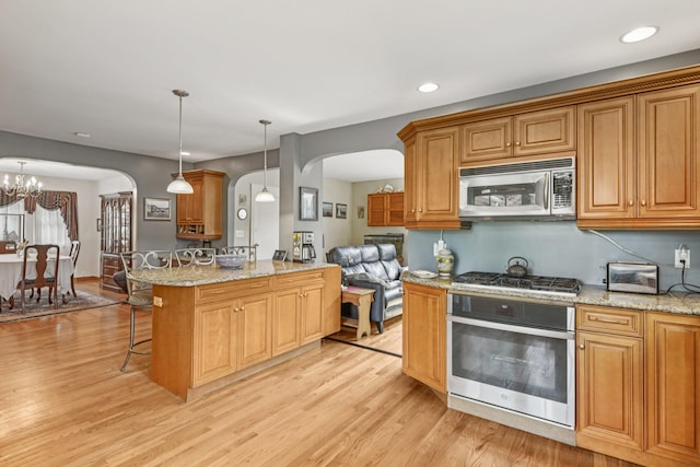 54 Ogden Ave, East Williston, NY 11596 - kitchen featuring stainless steel appliances, arched walkways, light wood-style flooring, and recessed lighting