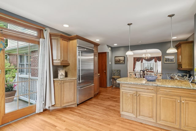 54 Ogden Ave, East Williston, NY 11596 - kitchen with built in fridge, light wood-style floors, a peninsula, pendant lighting, and a chandelier