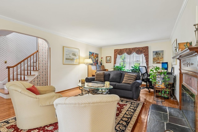 54 Ogden Ave, East Williston, NY 11596 - living room with a tiled fireplace, stairway, wood finished floors, crown molding, and arched walkways