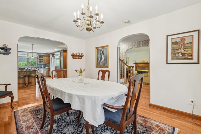 54 Ogden Ave, East Williston, NY 11596 - dining room featuring arched walkways, a chandelier, and light wood-style floors