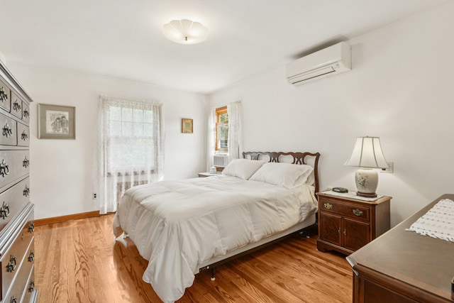 54 Ogden Ave, East Williston, NY 11596 - bedroom featuring a wall unit AC, light wood finished floors, radiator heating unit, and baseboards