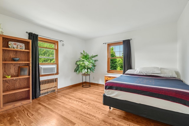 54 Ogden Ave, East Williston, NY 11596 - bedroom featuring radiator heating unit, multiple windows, wood finished floors, and baseboards