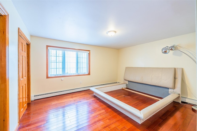 145-04 21st Ave, Whitestone, NY 11357 - bedroom with a baseboard heating unit and wood-type flooring