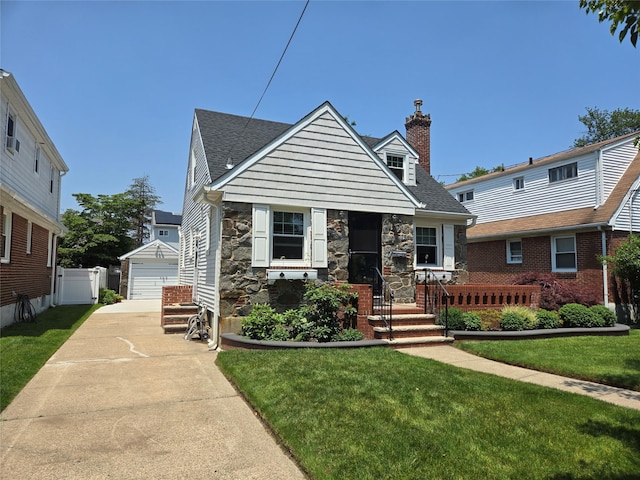 29 Irving St, Valley Stream, NY 11580 - view of front of home with stone siding, a chimney, an outbuilding, and a garage