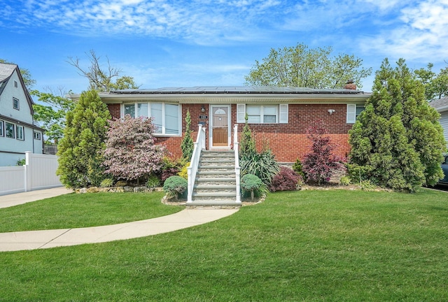 123 Baker Ct, Island Park, NY 11558 - view of front of home featuring brick siding, solar panels, and a chimney
