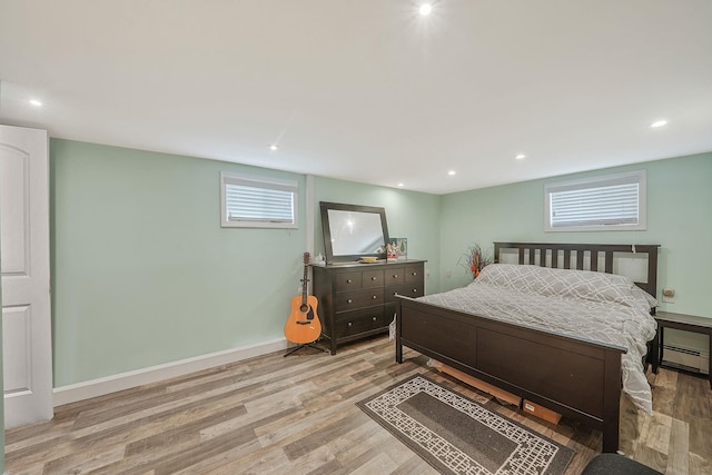 123 Baker Ct, Island Park, NY 11558 - bedroom featuring light wood-type flooring, a baseboard heating unit, recessed lighting, and baseboards