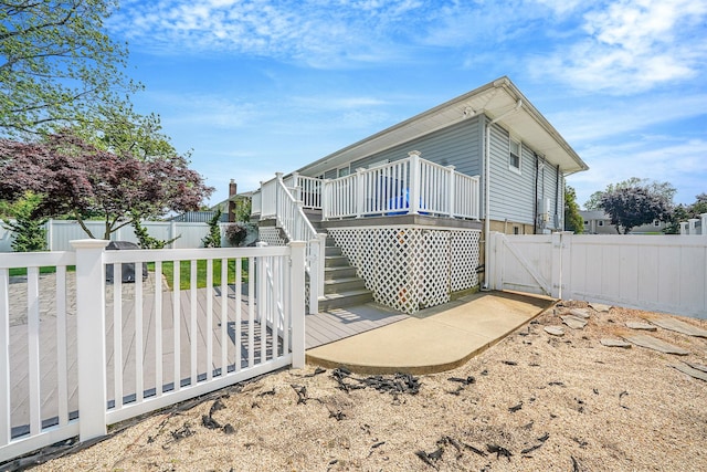 123 Baker Ct, Island Park, NY 11558 - view of side of home featuring a deck, a fenced backyard, a gate, and stairway