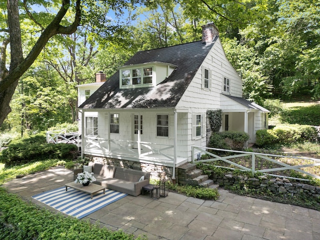 200 Millwood Rd, Chappaqua, NY 10514 - back of house featuring a chimney, a patio area, an outdoor hangout area, and view of wooded area