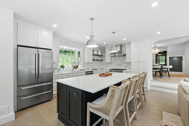 200 Millwood Rd, Chappaqua, NY 10514 - kitchen with stainless steel appliances, wall chimney exhaust hood, white cabinets, light countertops, and recessed lighting