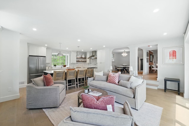 200 Millwood Rd, Chappaqua, NY 10514 - living room with arched walkways, recessed lighting, baseboards, light wood finished floors, and a chandelier