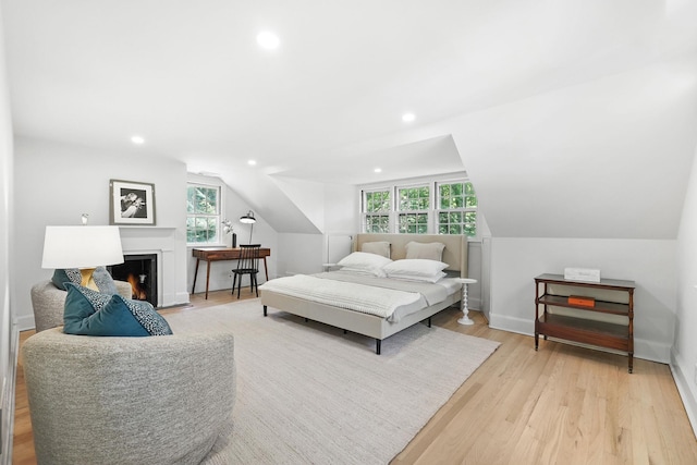 200 Millwood Rd, Chappaqua, NY 10514 - bedroom featuring recessed lighting, light wood finished floors, vaulted ceiling, a warm lit fireplace, and baseboards