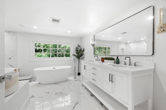 200 Millwood Rd, Chappaqua, NY 10514 - bathroom featuring double vanity, healthy amount of natural light, a freestanding bath, recessed lighting, and marble tiled floors