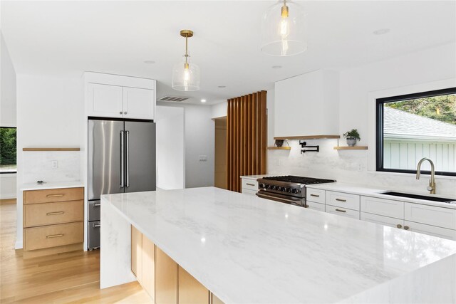 10 Lenape Rd, Southampton, NY 11968 - kitchen with a sink, stainless steel appliances, light wood-type flooring, and tasteful backsplash