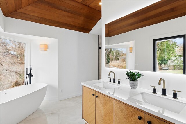 10 Lenape Rd, Southampton, NY 11968 - bathroom with double vanity, lofted ceiling, healthy amount of natural light, a freestanding tub, and wooden ceiling