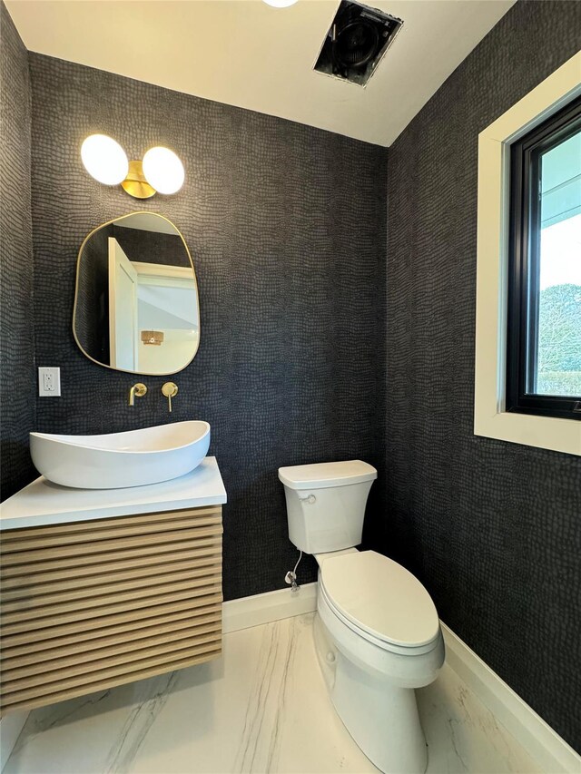 10 Lenape Rd, Southampton, NY 11968 - bathroom featuring marble look tile flooring, vanity, toilet, and baseboards