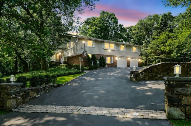 125 Park Ln, West Harrison, NY 10604 - view of front of property featuring asphalt driveway, an attached garage, and brick siding