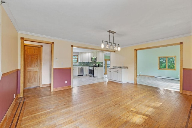 4 W Burda Pl, New City, NY 10956 - unfurnished living room featuring light wood-type flooring, baseboard heating, ornamental molding, and baseboards