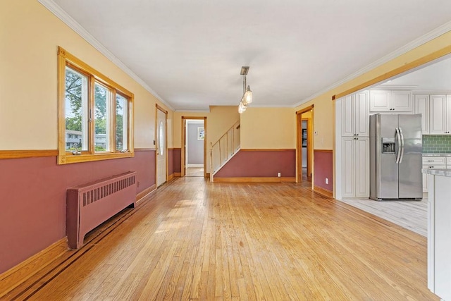 4 W Burda Pl, New City, NY 10956 - empty room featuring radiator heating unit, stairway, light wood finished floors, baseboards, and crown molding