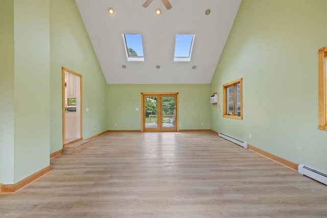 4 W Burda Pl, New City, NY 10956 - spare room featuring a skylight, high vaulted ceiling, a baseboard heating unit, light wood-type flooring, and baseboards