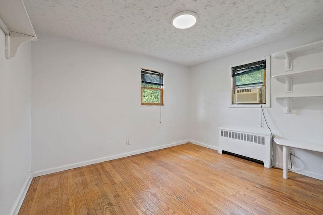4 W Burda Pl, New City, NY 10956 - empty room with radiator heating unit, light wood-style floors, cooling unit, a textured ceiling, and baseboards