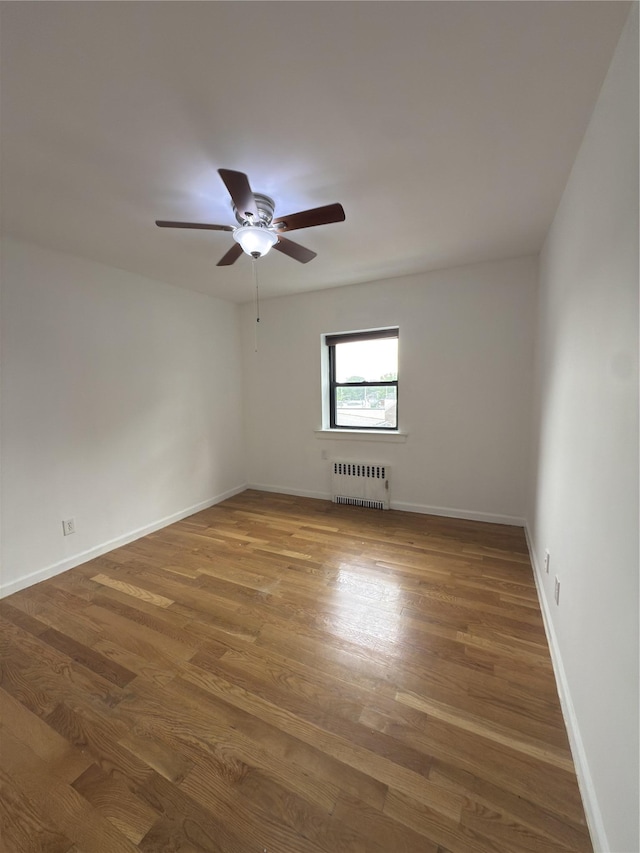 240 Halstead Ave Unit C8, Harrison, NY 10528 - spare room with radiator, wood finished floors, ceiling fan, and baseboards