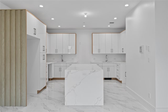 244 Blauvelt Rd Unit 213, Monsey, NY 10952 - kitchen with recessed lighting, light marble finish flooring, light stone countertops, a center island, and white cabinets