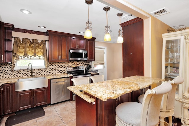 32 Cedar St, Lindenhurst, NY 11757 - kitchen featuring appliances with stainless steel finishes, a sink, decorative backsplash, a kitchen breakfast bar, and recessed lighting