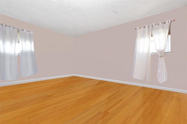 32 Cedar St, Lindenhurst, NY 11757 - spare room with light wood-style floors, baseboards, a textured ceiling, and lofted ceiling