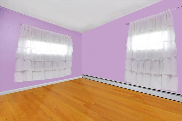 32 Cedar St, Lindenhurst, NY 11757 - spare room featuring baseboard heating, wood finished floors, and baseboards