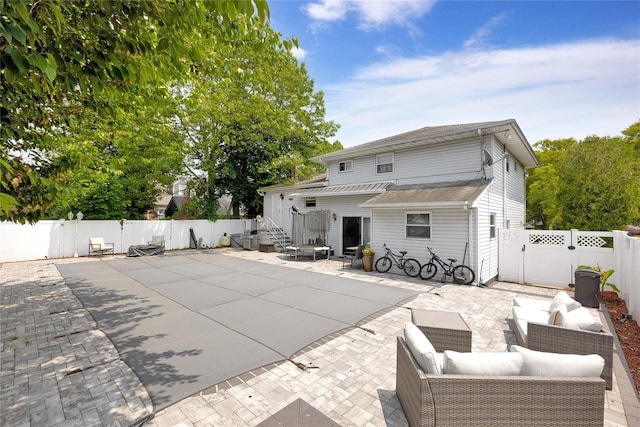 32 Cedar St, Lindenhurst, NY 11757 - back of property with an outdoor living space, a fenced backyard, a gate, and a patio area
