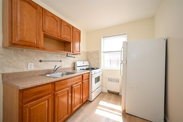 20-21 Parsons Blvd, Whitestone, NY 11357 - kitchen with white appliances, radiator heating unit, light wood-style floors, brown cabinets, and decorative backsplash