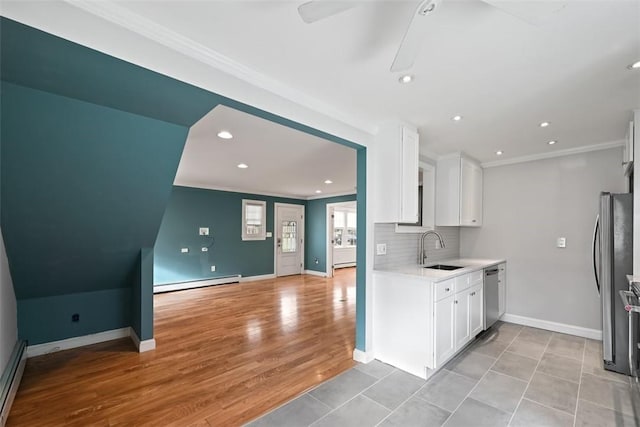 513 3rd St, Newburgh, NY 12550 - kitchen featuring ornamental molding, stainless steel appliances, baseboard heating, a ceiling fan, and light countertops