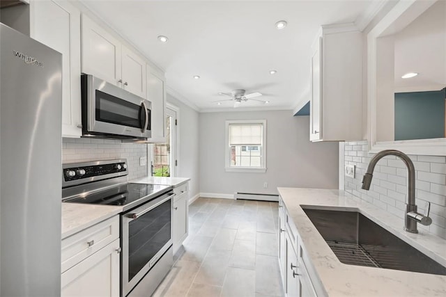 513 3rd St, Newburgh, NY 12550 - kitchen with appliances with stainless steel finishes, baseboard heating, light stone counters, recessed lighting, and crown molding