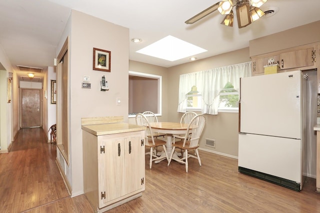 11 Claremont Ln, Suffern, NY 10901 - kitchen with freestanding refrigerator, light wood-style flooring, a skylight, light countertops, and a ceiling fan